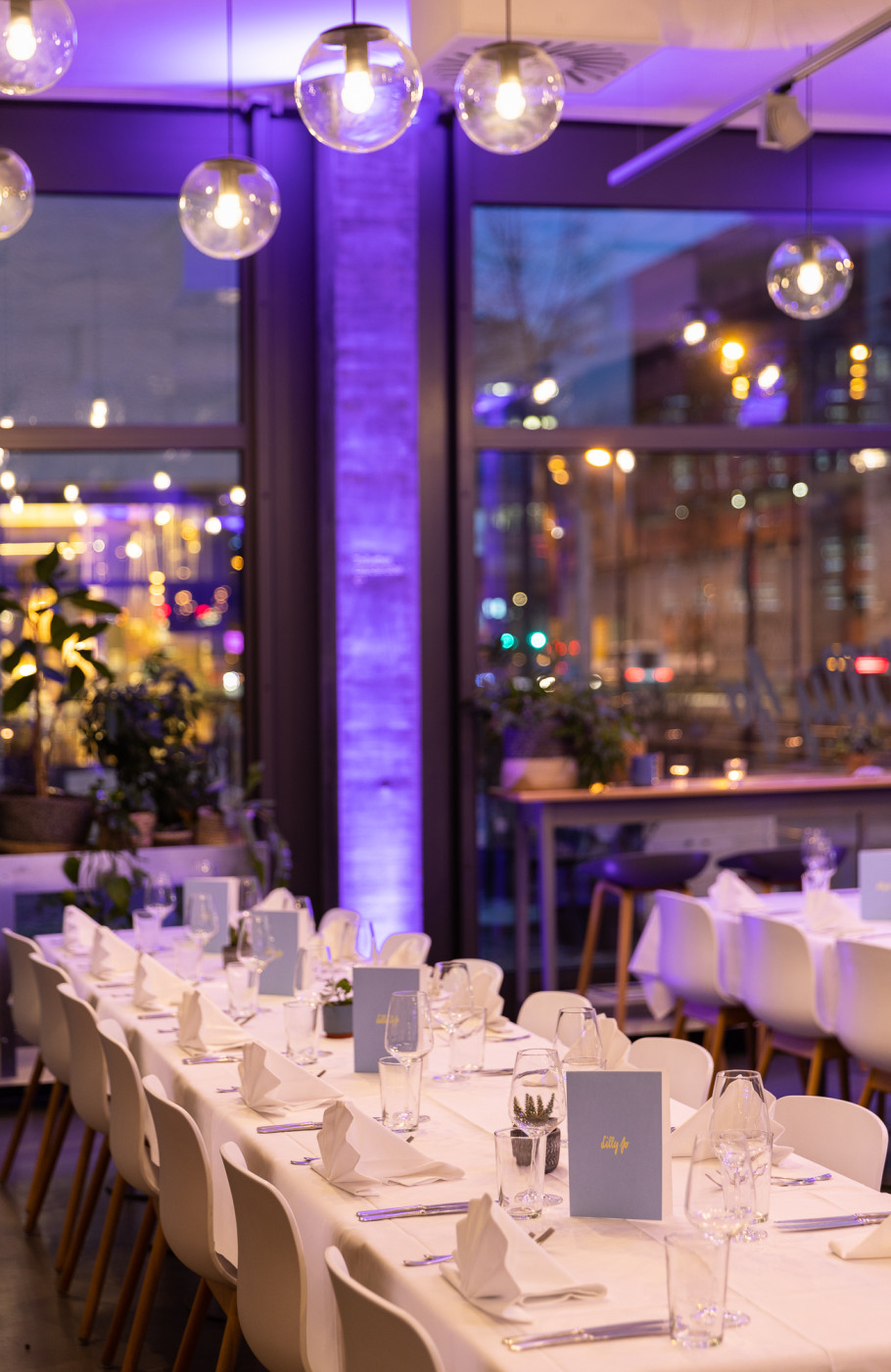 Restaurant Lilly Jo Weihnachtsfeier Tisch Setup mit lila Beleuchtung im Hintergrund