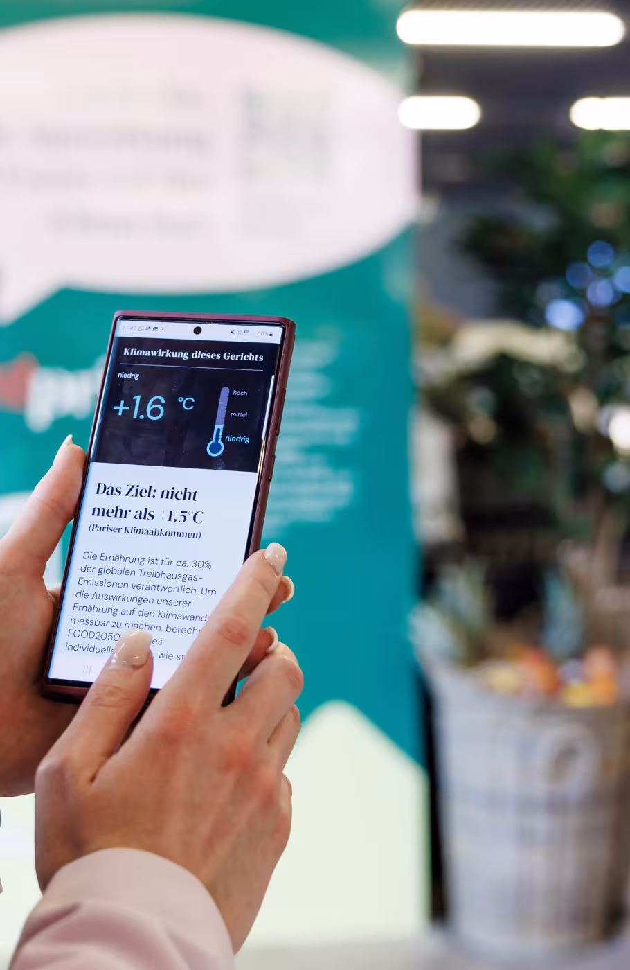 Umweltauswirkungen auf Handy gehalten von einer Frau