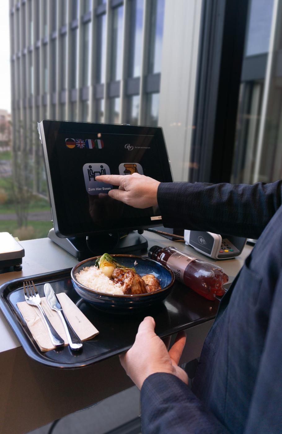 Männerhand bedient einen Self-Check-out in einem Restaurant