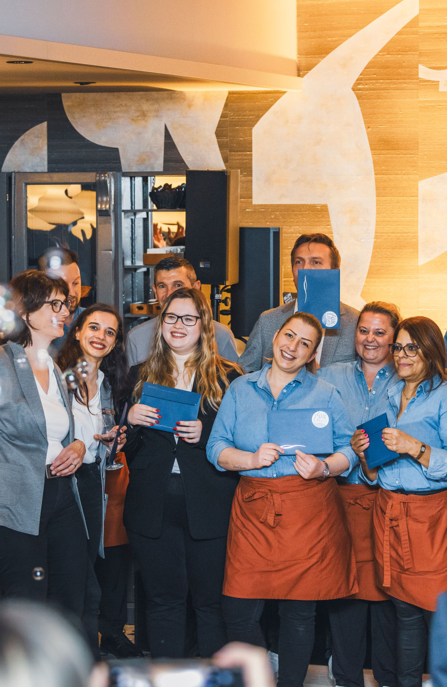 Gastronomieteam in blau-orangen Uniformen