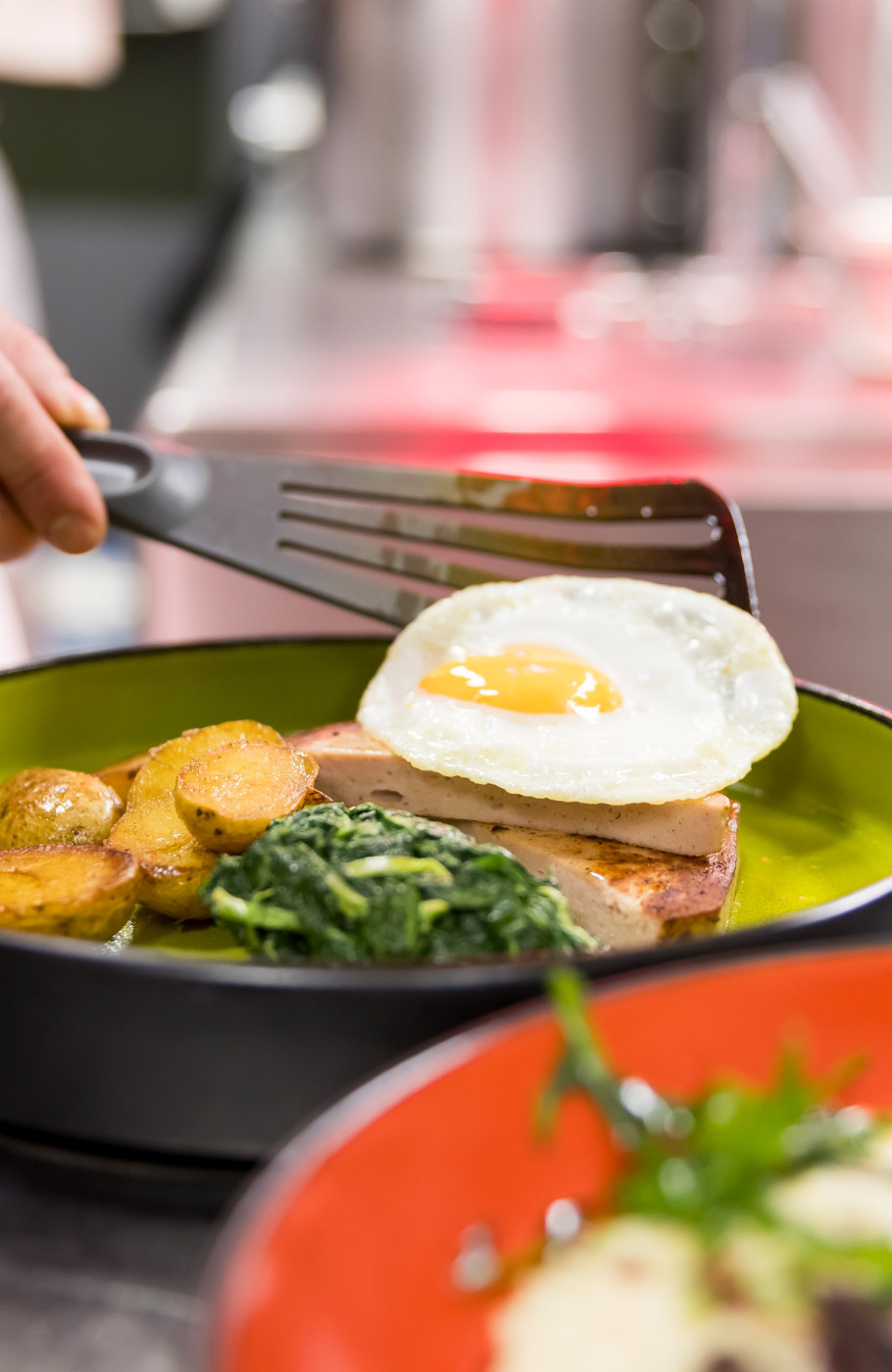 Anrichtes eines Tellers mit Spiegelei und Fleischkäse