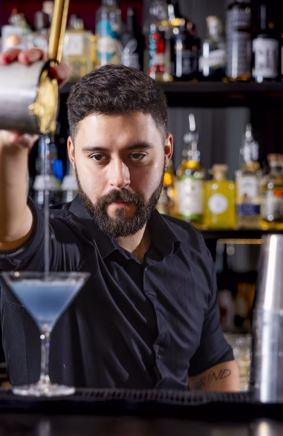 Bartender giesst Cocktail in ein Glas
