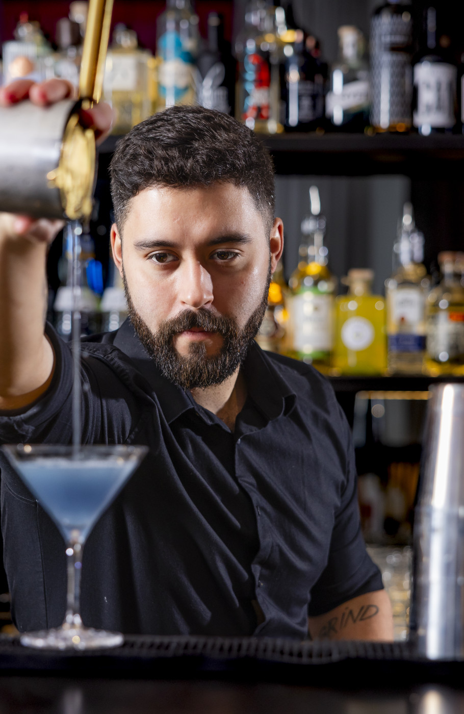 Bartender giesst Cocktail in ein Glas