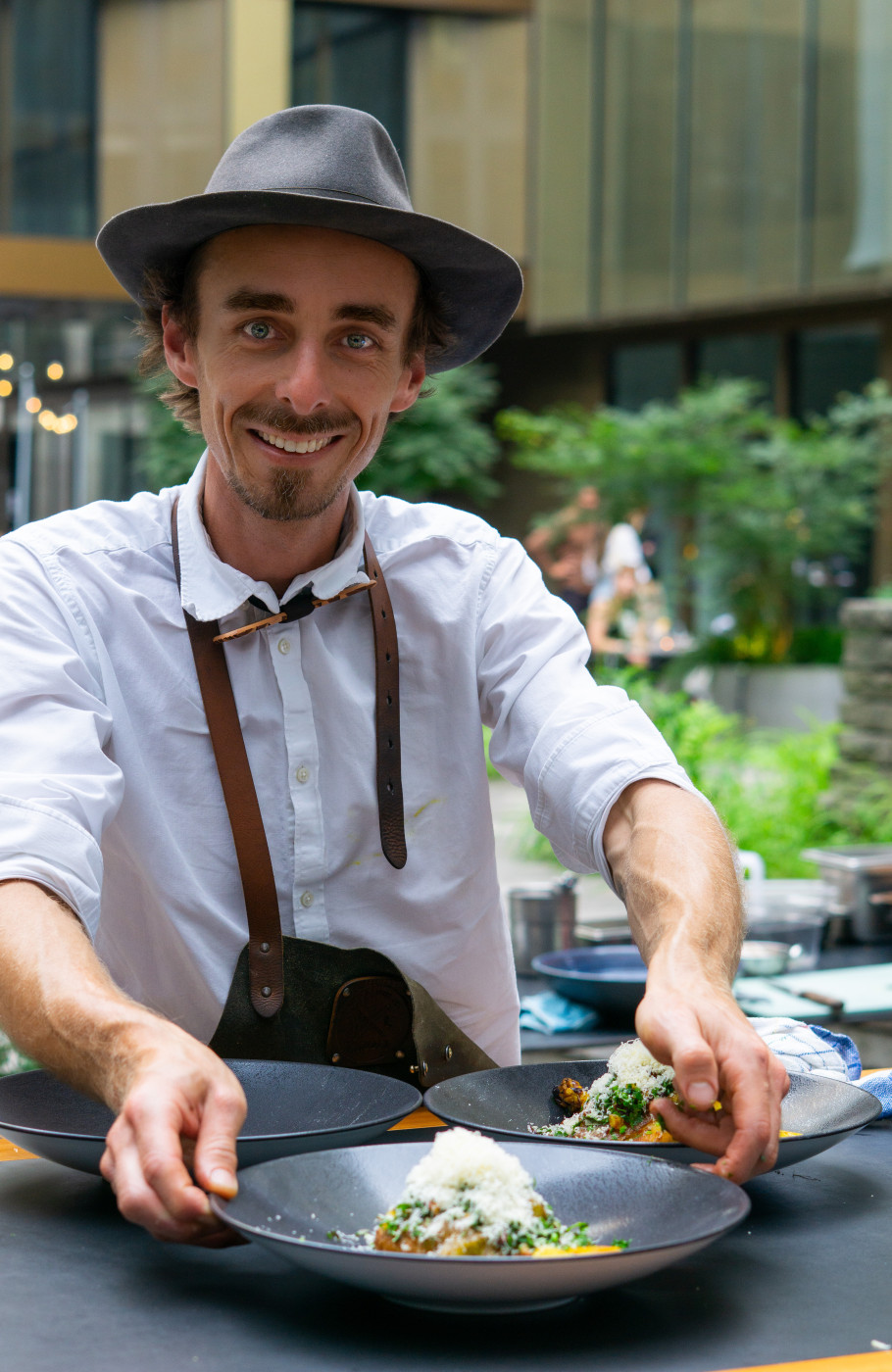 Mann mit Hut hält Bowl und lächelt