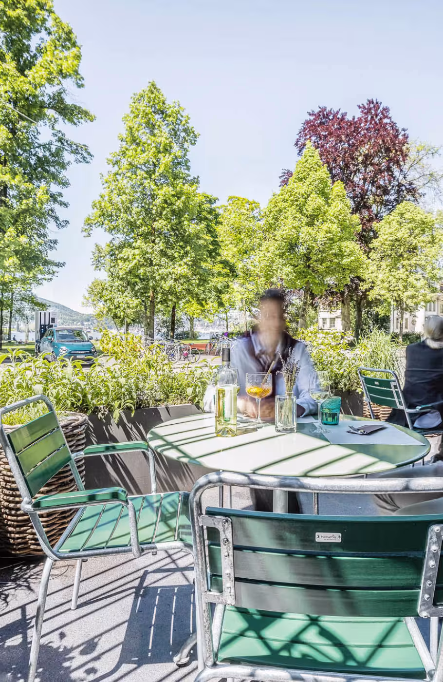 Der Garten mit Tischen und Pflanzen der Brasserie