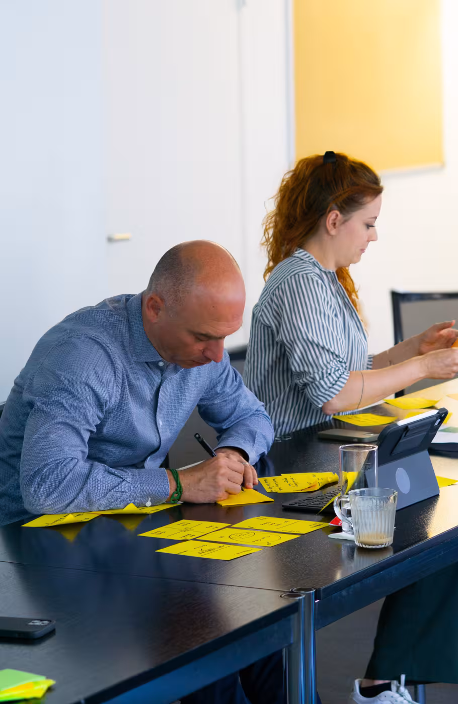 Zwei Personen sitzen an einem Tisch und arbeiten Ideen aus