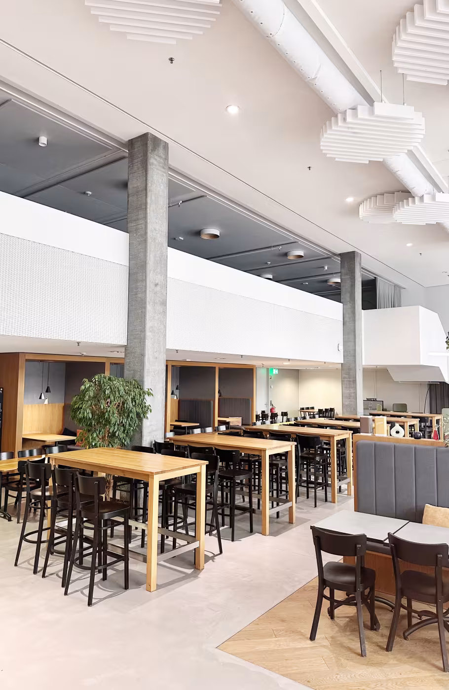 Innenansicht des Power Inn Baden mit Hochtischen, flexiblen Sitzbereichen und modernem Eventambiente