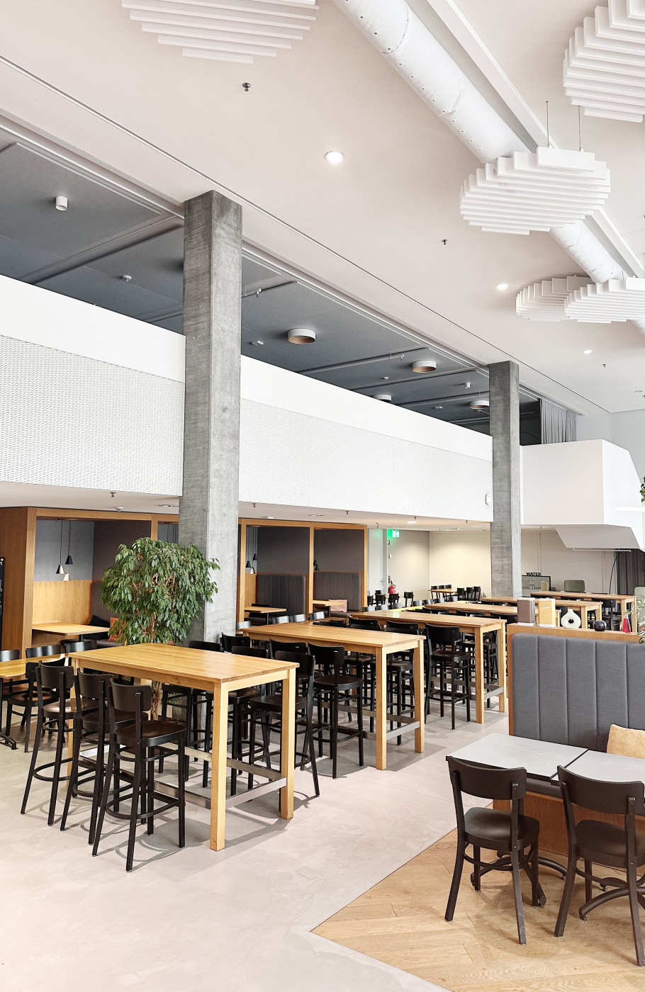 Innenansicht des Power Inn Baden mit Hochtischen, flexiblen Sitzbereichen und modernem Eventambiente