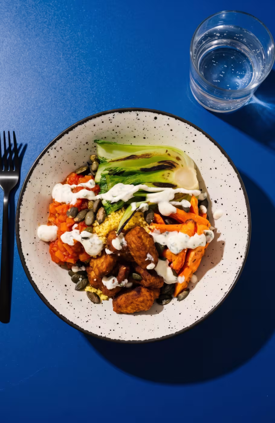 Weisser Teller mit asiatischer Bowl mit Gemüse und Sauce