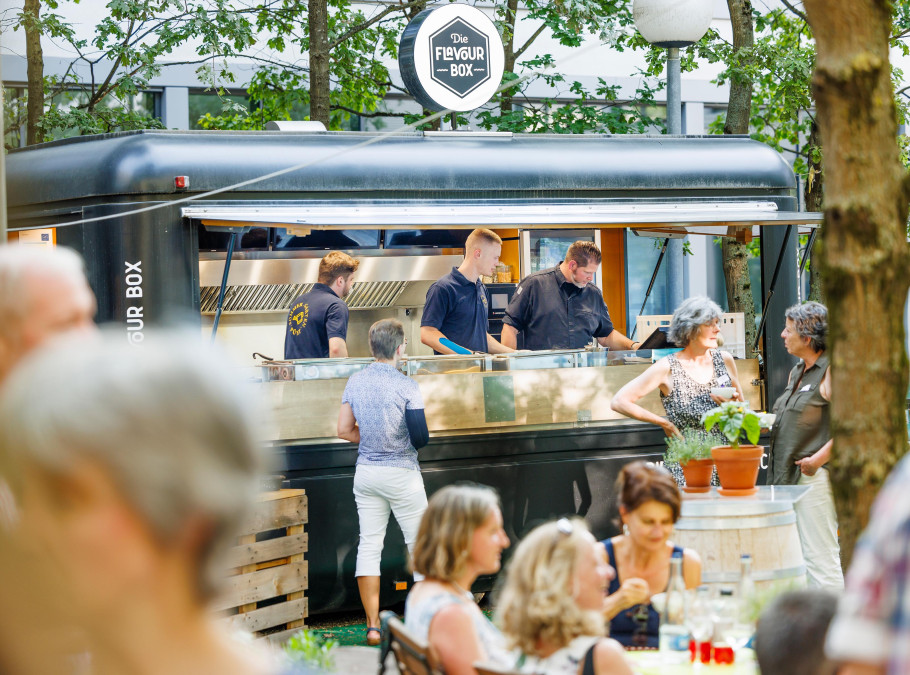 Gäste stehen beim Foodtruck im Pünt Sommergarten an