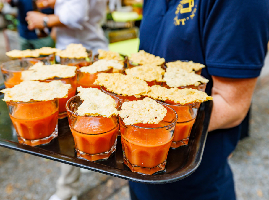 Person serviert Gazpacho im Pünt Sommergarten