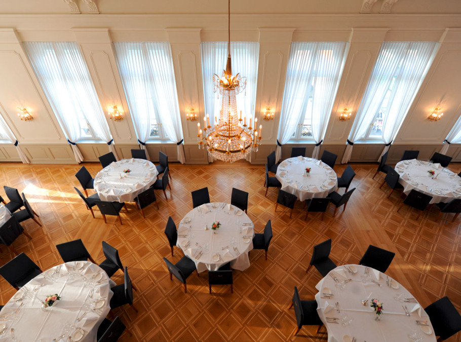Bankettsaal von oben mit runden Eventtischen und edlem Parkett