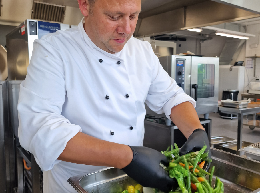 Koch bei der Zubereitung von frischem Salat