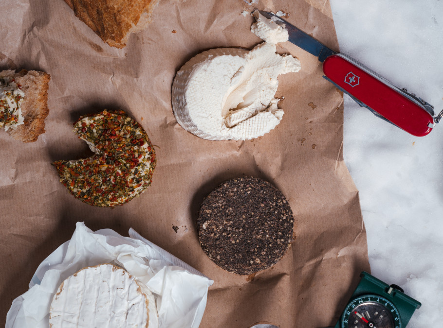 Veganer Käse mit Brot in der Vogelperspektive auf einem Holzbrett angerichtet