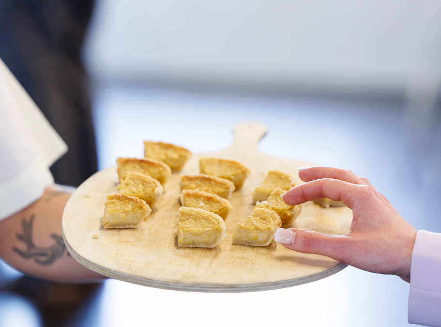 Käsekuchen gereicht von einer männlichen Hand