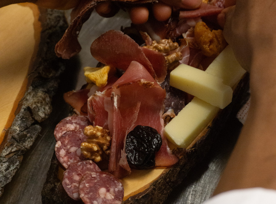 Männliche Hände richten eine kalte Platte mit Fleisch und Käse an