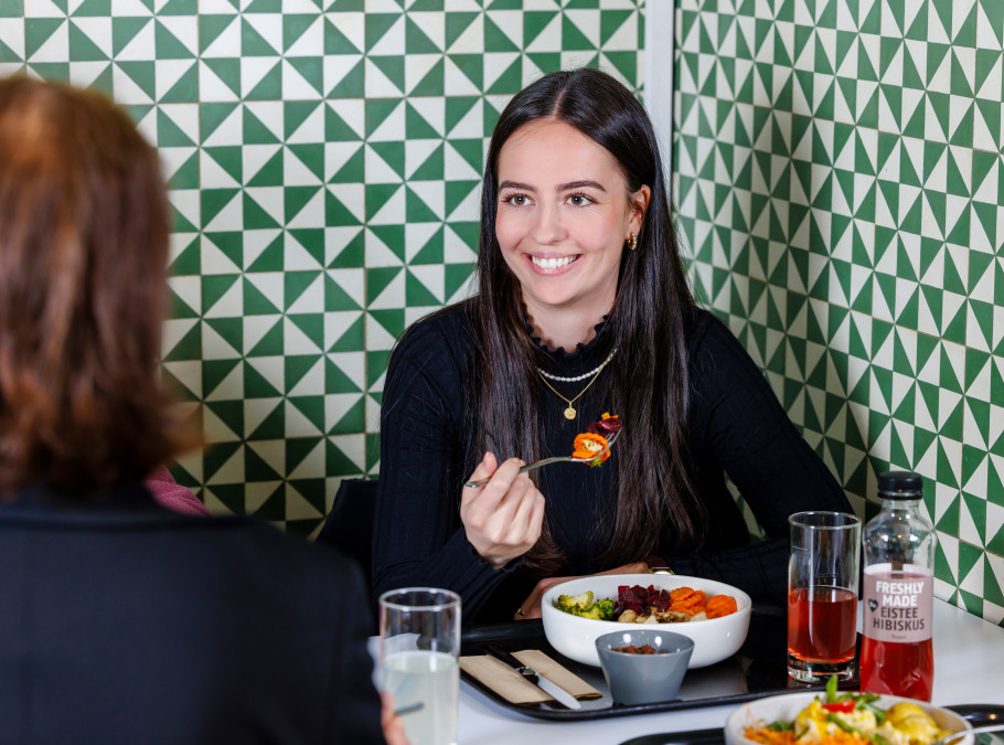 Frau beim Lunch in einem bunten Ort