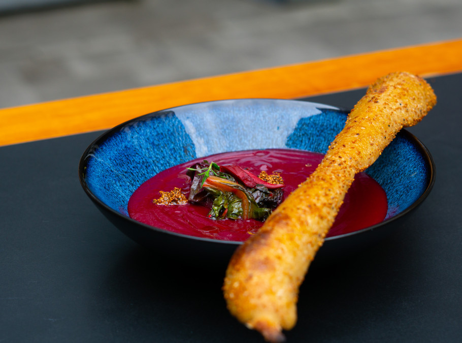 Blaue Schale mit Randensupper und Brotstange