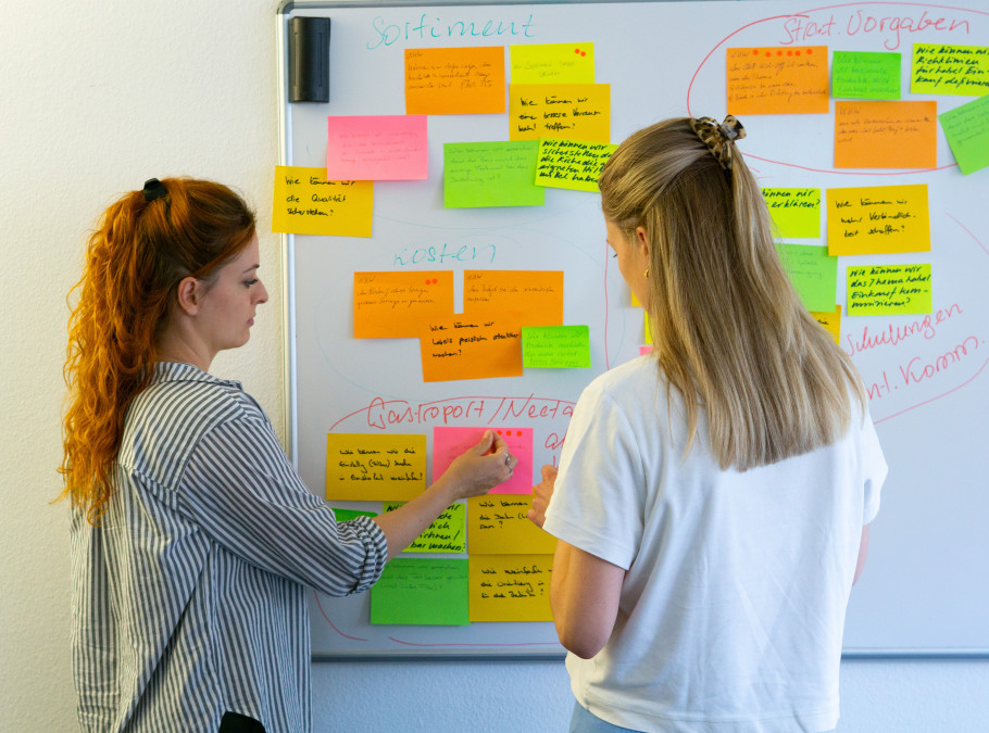 Zwei Frauen stehen an einem Whiteboard
