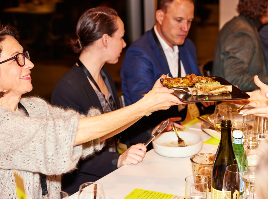 Tisch mit zwei Frauen, die sich eine Platte reichen