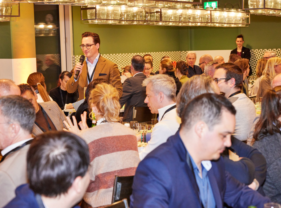 Menschenmenge mit einer Person mit Mikrophon in der Mitte