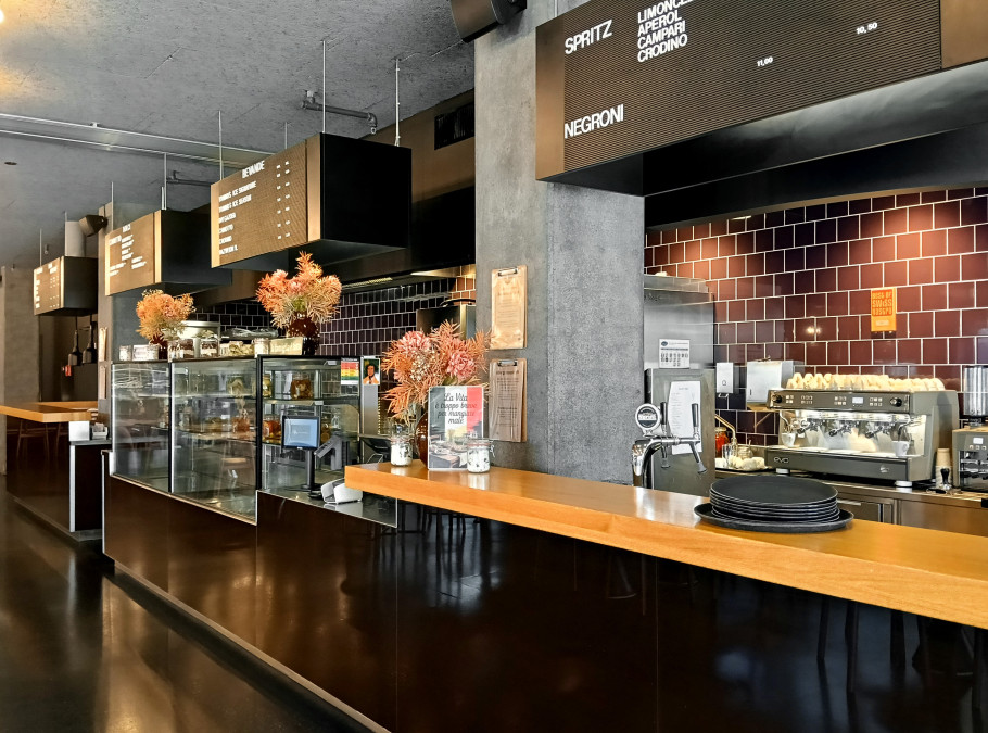Barbereich der Eventlocation Bistro Tonino in Zürich mit Holztheke, Getränkevitrine und modernem Gastronomieambiente für Firmenanlässe und Events.