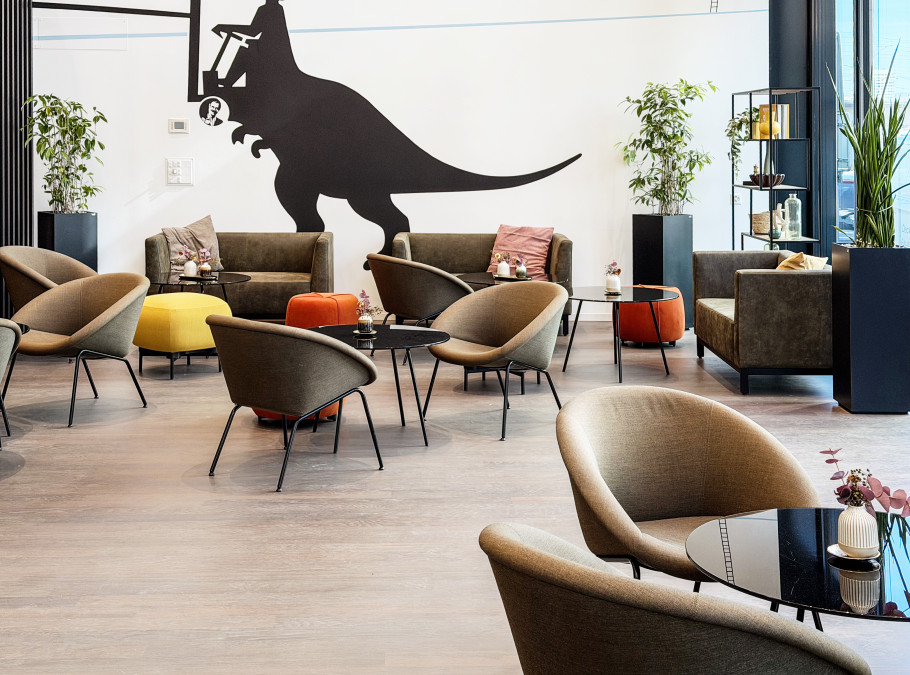 Loungebereich im EY Platform in Zürich mit Sesseln und markanter Wandkunst.