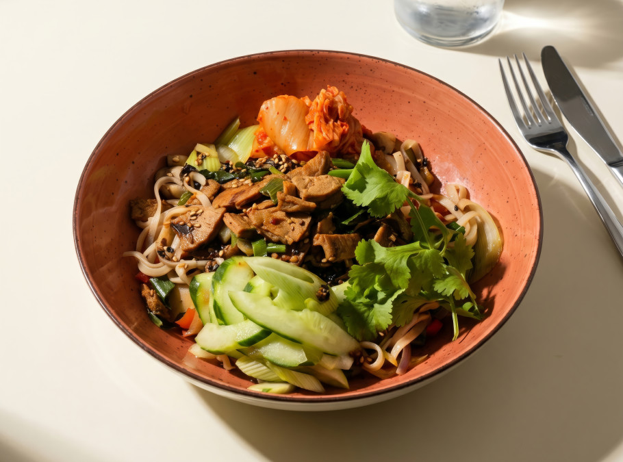 Oranger Teller mit Bibimbap auf einem Tisch