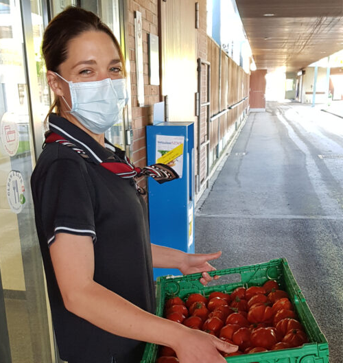 ZFV-Mitarbeiterin hält Kiste mit geretteten Tomaten in der Hand