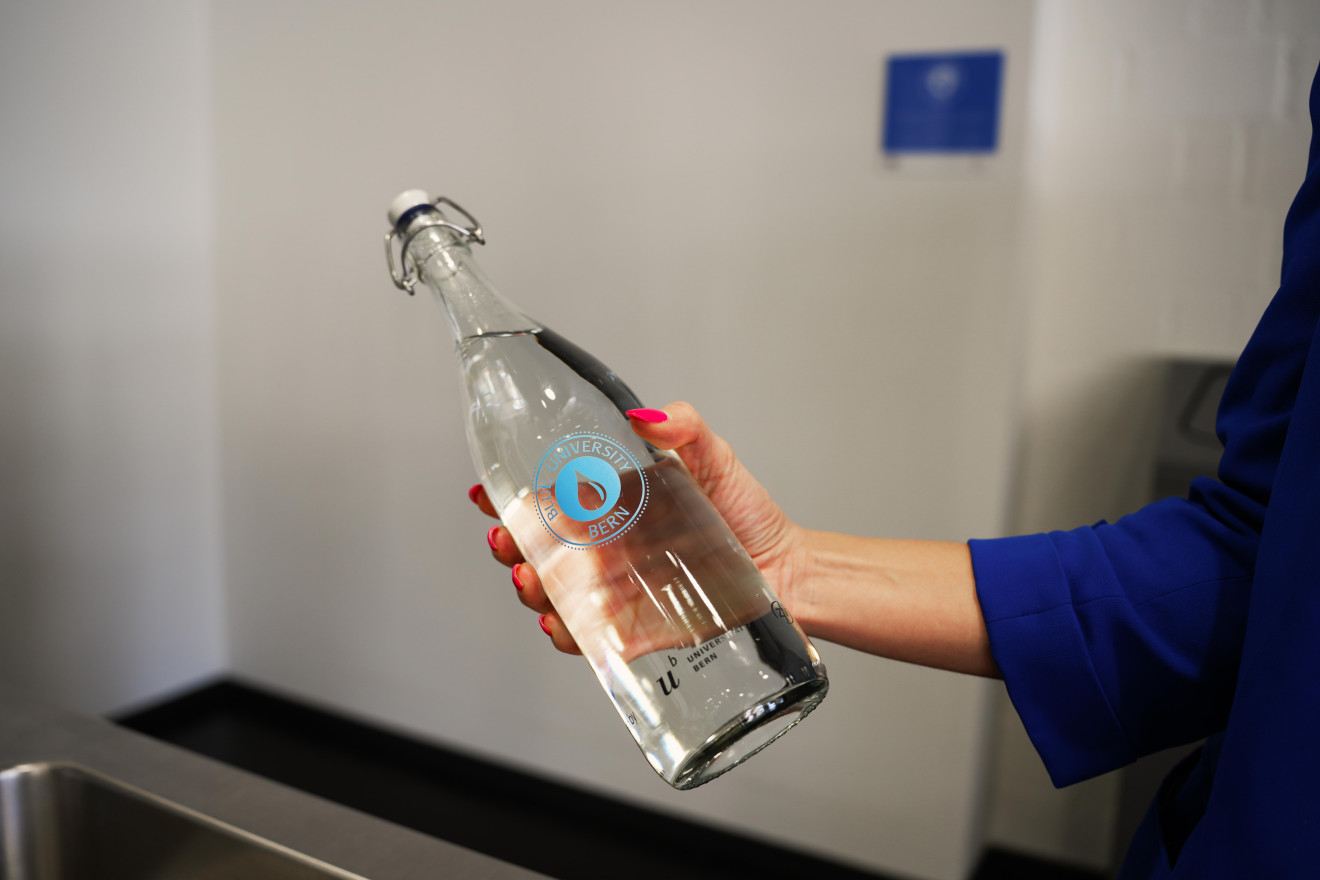 Arm hält Wasserflasche