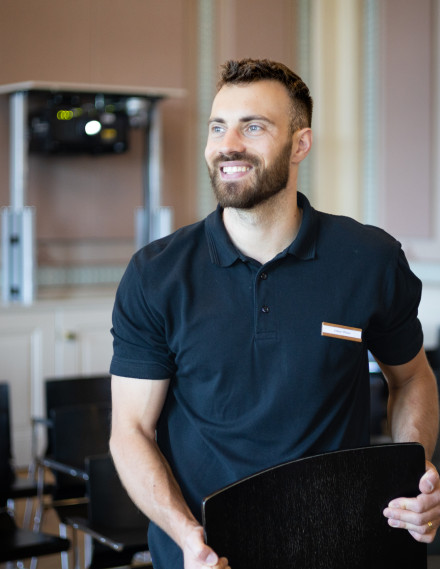 Mann steht in einem Restaurant und lächelt