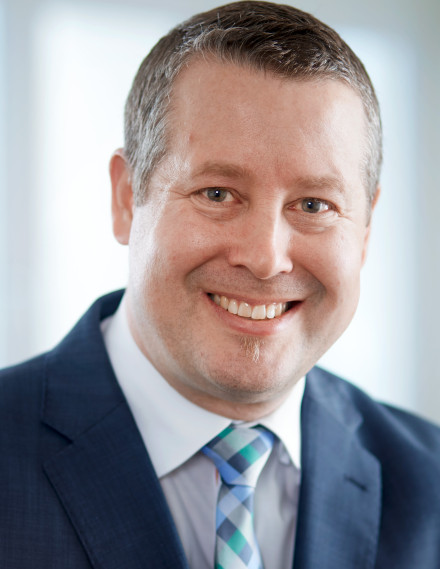 Mann im Anzug lächelt in die Kamera, Porträt