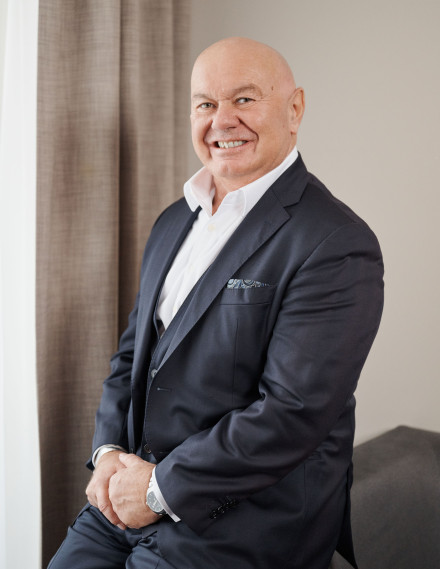 Mann lächelt sitzend in die Kamera