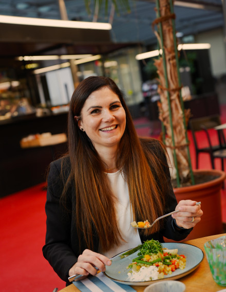 Frau sitzt lachend am Tisch
