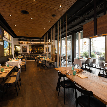 modernes Restaurant mit Holzinterieur, Fensterfront und bunter Wand