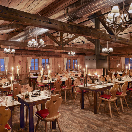 Inneneinrichtung im Chalet Zürichberg mit urigen Holztischen und Stühlen