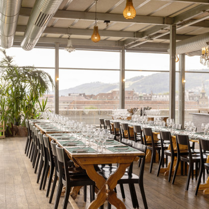 Für Events gedeckte Tische aus dunklem Holz im Restaurant Grosse Schanze