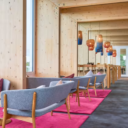 Designer Inneneinrichtung im nordischen Stil mit hellblauen Sesseln bunten Lampen im Restaurant Bellavista 