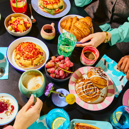 Gedeckter Tisch mit Händen bei einem Frühstück
