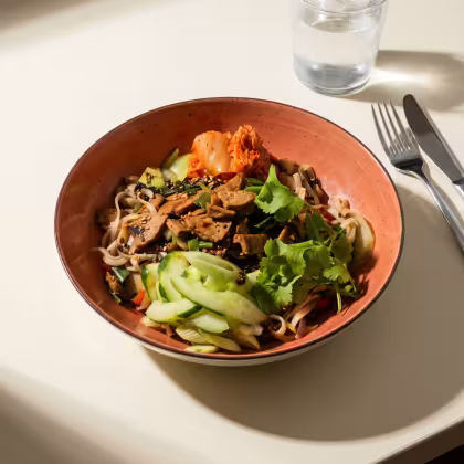 Oranger Teller mit Bibimbap auf einem Tisch