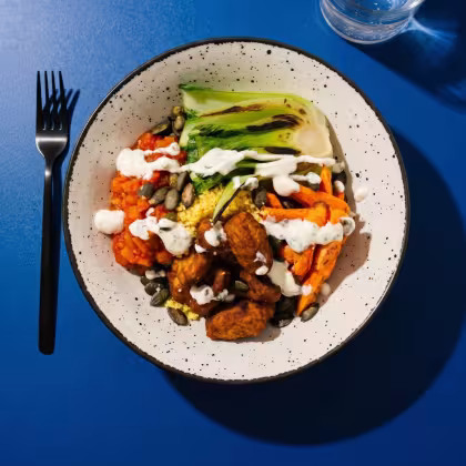 Weisser Teller mit asiatischer Bowl mit Gemüse und Sauce