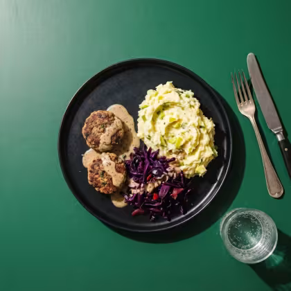Schwarzer Teller mit Hacktätschli, Kartoffelstock und Blaukraut