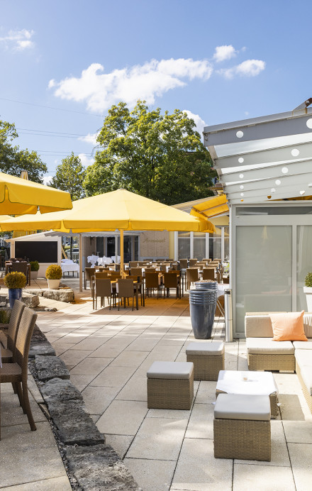 Terrasse mit Tischen, Stühlen und Sonnenschirmen des Sorell Hotels Sonnental