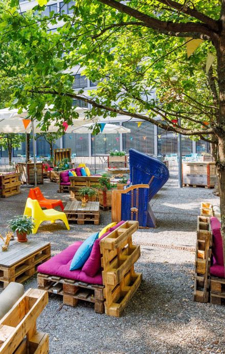 Lounges, Tische und farbenfrohe Kissen im Pünt Sommergarten
