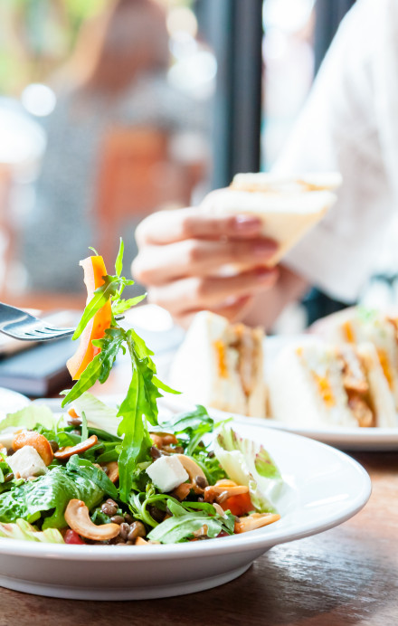 Personen essen Salat am Tisch