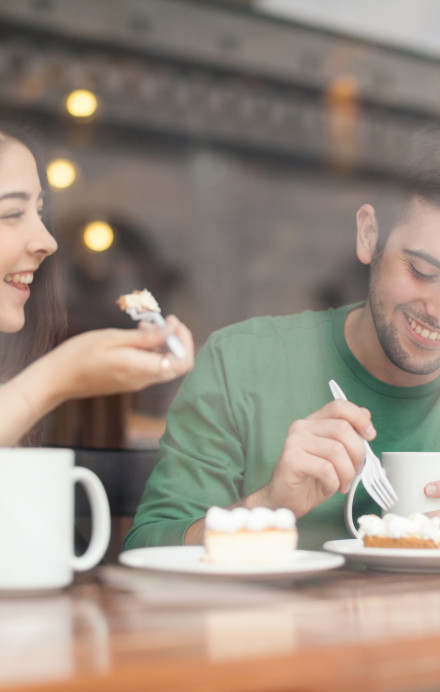 Mann und Frau in einer Cafeteria am Kaffee trinken und essen