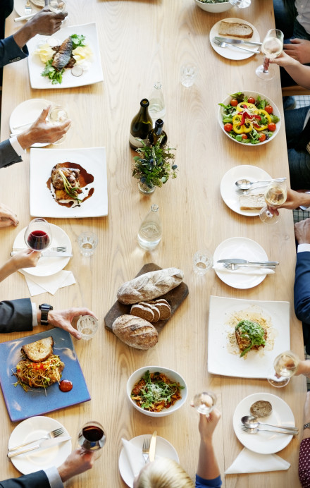 Personen an einem langen Tisch beim Mittagessen
