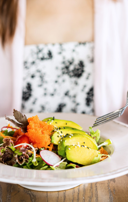 Frau isst ein Salat in einem Restaurant