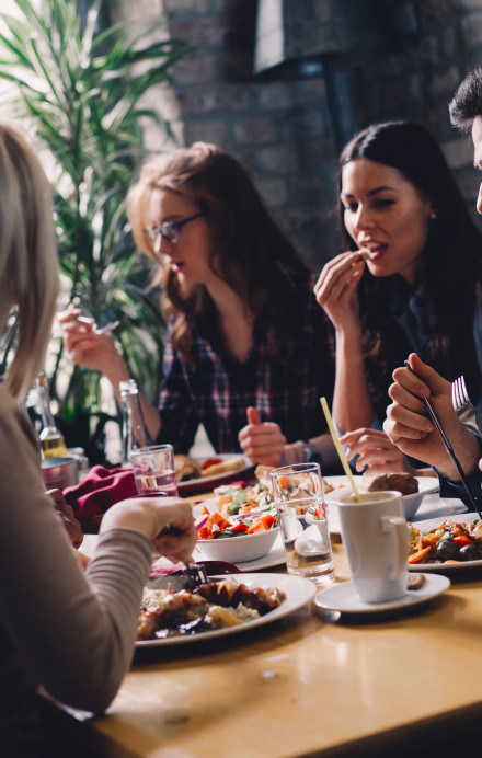 Gäste eines Restaurants an einem Tisch am Mittagessen