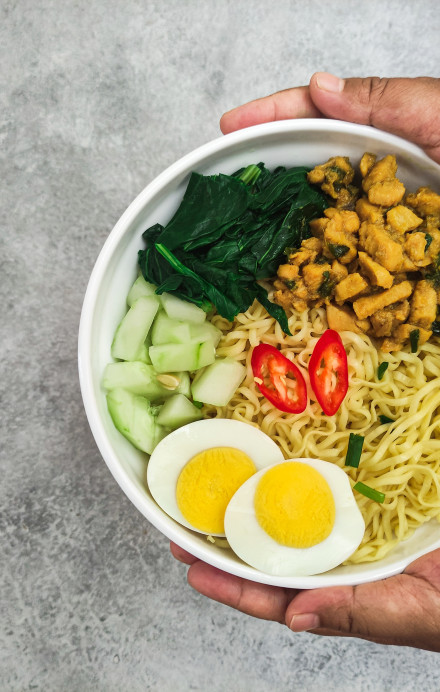 Person hält eine vegetarische Bowl in der Hand